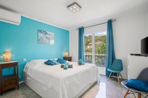 a blue bedroom with a bed and a window at Villa Etoile in Cabasse +32 photos