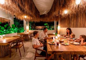 a family sitting at a table in a restaurant at Lombok Souls in Senggigi