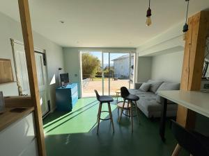 a living room with a couch and two stools at L'échappée verte in Chirens