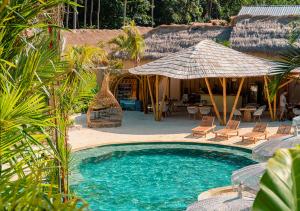 a swimming pool with chairs and an umbrella at Lombok Souls in Senggigi