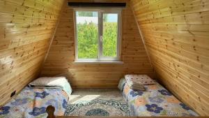 two beds in a log cabin with a window at JEEK A-Frame in Tong