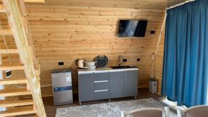 a kitchen with a sink and a tv on a wooden wall at JEEK A-Frame in Tong