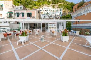 a patio with tables and chairs on a building at Amalfi Suite Boutique Hotel in Amalfi
