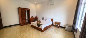 a bedroom with a bed and a mirror at Khmer House Kampot Boutique in Kampot