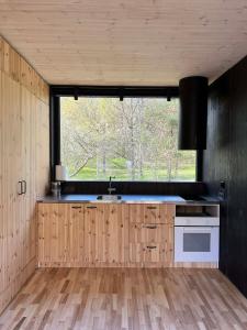 a kitchen with wooden cabinets and a large window at Premium homes in VNO