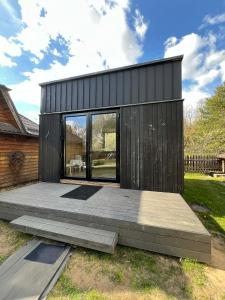a black tiny house with a wooden deck at Premium homes in VNO