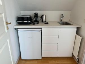 a kitchen counter with a sink and a microwave at Bed and Breakfast Ringsted Syd in Ringsted