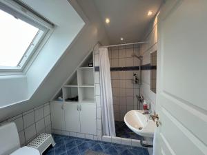 a bathroom with a sink and a toilet and a window at Bed and Breakfast Ringsted Syd in Ringsted +4 photos