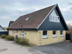 a yellow house with a black roof at Bed and Breakfast Ringsted Syd in Ringsted