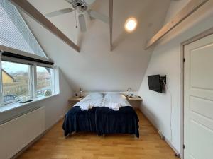 a bedroom with a bed and a ceiling fan at Bed and Breakfast Ringsted Syd in Ringsted