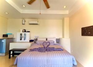 a bedroom with a bed with a purple ribbon on it at Viking House Apartment in Ko Tao +14 photos