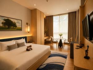 a hotel room with a bed with a teddy bear on it at AZ Sunrise Resort & Fitness Club in Layan Beach +74 photos