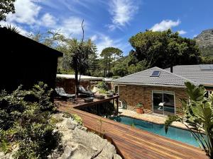 a home with a swimming pool and a house at Tranquility in Cape Town