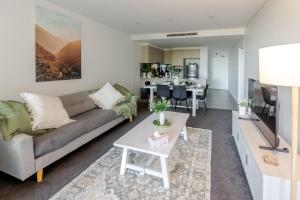 a living room with a couch and a table at On Flinders Wollongong in Wollongong