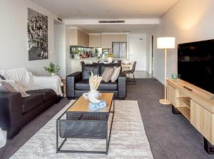 a living room with a couch and a tv at On Flinders Wollongong in Wollongong