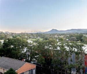 a view of a city with mountains in the distance at On Flinders Wollongong in Wollongong