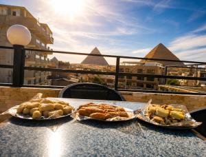 three plates of food sitting on a table on a balcony at Red pyramids view hotels in Cairo +29 photos