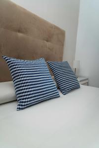 two blue and white pillows sitting on a bed at Piso en Casa de Correos in Molina de Aragón