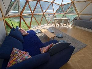 a living room with a blue couch in a yurt at Kopuła in Gdynia