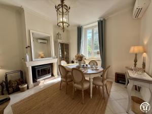 a dining room with a table and chairs and a fireplace at Un brin lavande in Saint-Couat-dʼAude