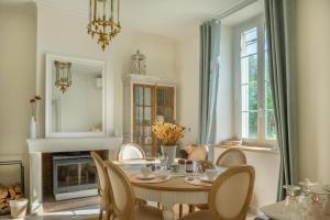 a dining room with a table and chairs and a fireplace at Un brin lavande in Saint-Couat-dʼAude +17 photos