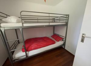 a bedroom with two bunk beds with red sheets at Sommerhaus Seeblick in Klausdorf Brandenburg