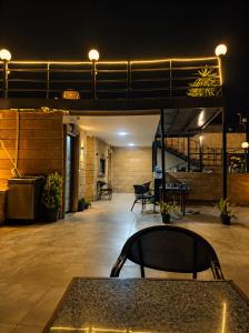 a patio with a table and chairs at night at Red pyramids view hotels in Cairo