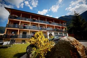 a building with balconies and a car parked in front of it at Pension Gstrein in Bad Hofgastein