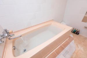 a white bath tub in a bathroom at Earn Exception in Isesaki