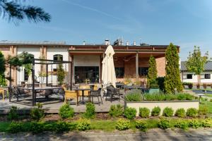 a patio with a table and a white umbrella at Salio Equisport Resort in Stryków