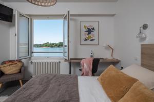 a bedroom with a bed and a large window at Logis Hôtel de la Pointe du Cap Coz in Fouesnant