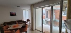 a living room with a table and a balcony at Apartmani MITIĆ in Veliko Gradište