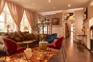 ein Wohnzimmer mit Sofa und roten Sesseln in der Unterkunft Hotel van Bebber in Xanten