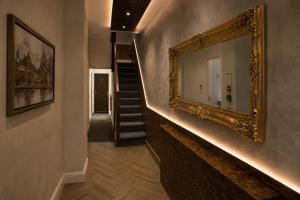 a hallway with a mirror on the wall and a staircase at Paddington Townhouse Hotel by OYO in London +20 photos