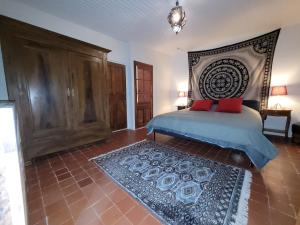a bedroom with a bed with a headboard and a rug at The Cozy Collo House in Collobrières