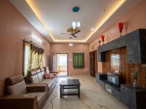 a living room with a couch and a table at SVL HomeStay in Chik Ballāpur