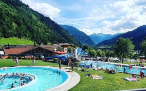 a group of people in a swimming pool in the mountains at Chalet Franzi - Ruhiges Chalet mit Bergblick, Garten und gratis Eintritt ins Solarbad in Dorfgastein
