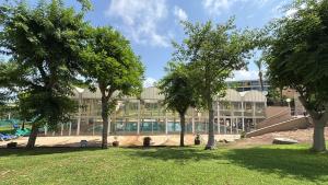 a large building with trees in front of it at ODAR suite in Caesarea