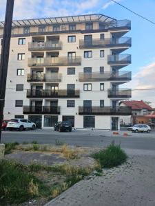 a large white building with cars parked in front of it at Apartman Marija IV in Vrnjačka Banja