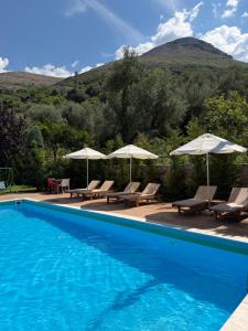 a swimming pool with chairs and umbrellas at Aparthotel Borsh in Borsh