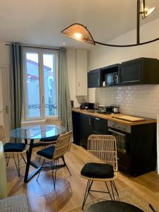 una cucina con tavolo e sedie in vetro e un bancone di Les Suites de Vanves - Parc des expositions Porte de Versailles a Vanves