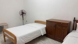 a bedroom with two twin beds and a fan at Beachfront Villa Sea View First Row in Dawwār ‘Abd Allāh