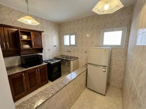 a kitchen with a refrigerator and a stove at Beachfront Villa Sea View First Row in Dawwār ‘Abd Allāh