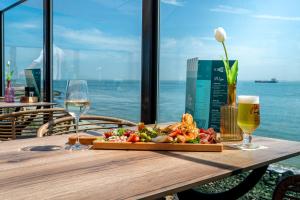 a wooden table with a tray of food and glasses of wine at Punt al Mare in Vlissingen