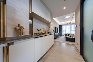 a kitchen with white cabinets and a living room at Ruilan Courtyard in Shenzhen