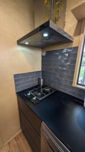 a kitchen with a black counter top with a stove at Nine77 - Tiny Home Retreat in Esperance +7 photos