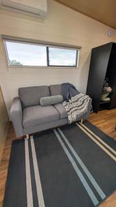 a couch sitting inside of a tiny house at Nine77 - Tiny Home Retreat in Esperance