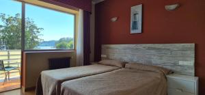 a bedroom with a bed and a large window at Las Islas in Vilaboa