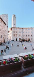 a group of people sitting around in a courtyard at Casa Becci Central Large & Sunlit Historical Flat in San Gimignano