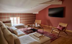 a living room with a couch and a flat screen tv at Villa Privée avec Piscine - Lavy in Saint-Pierre-de-Côle
